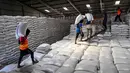 Penggunaan CBP yang dikelola Perum Bulog di tiga provinsi tersebut sedang diintensifkan untuk pelaksanaan program bantuan pangan reguler dan nonreguler. Tampak dalam foto, para pekerja menangani karung-karung beras†di gudang Badan Urusan Logistik (Bulog) di Lambaro, Provinsi Aceh pada 29 Desember 2025. (CHAIDEER MAHYUDDIN/AFP)