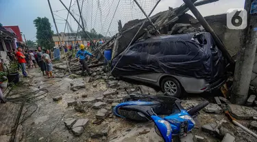 Warga menyaksikan bangunan tembok lapangan Sekolah Amec yang roboh di Pamulang Elok, Tangerang selatan, Banten, Jumat (8/12/2023). (merdeka.com/Arie Basuki)