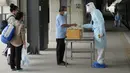 Petugas kesehatan memeriksa kadar oksigen pasien COVID-19 setibanya di Stasiun Rangsit, Provinsi Pathum Thani, Thailand, Selasa (27/7/2021). Pengiriman pasien COVID-19 dari Bangkok ke kota asal mereka ini untuk meringankan beban sistem medis ibu kota yang kewalahan. (AP Photo/Sakchai Lalit)