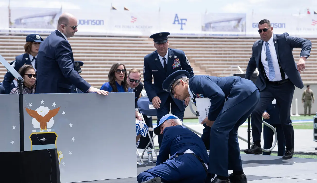 Biden menyapa para lulusan di Colorado Springs, Colorado, dengan memberi hormat dan jabat tangan kemudian berbalik untuk kembali ke tempat duduknya ketika akhirnya malah terjatuh. (Photo by Brendan Smialowski / AFP)