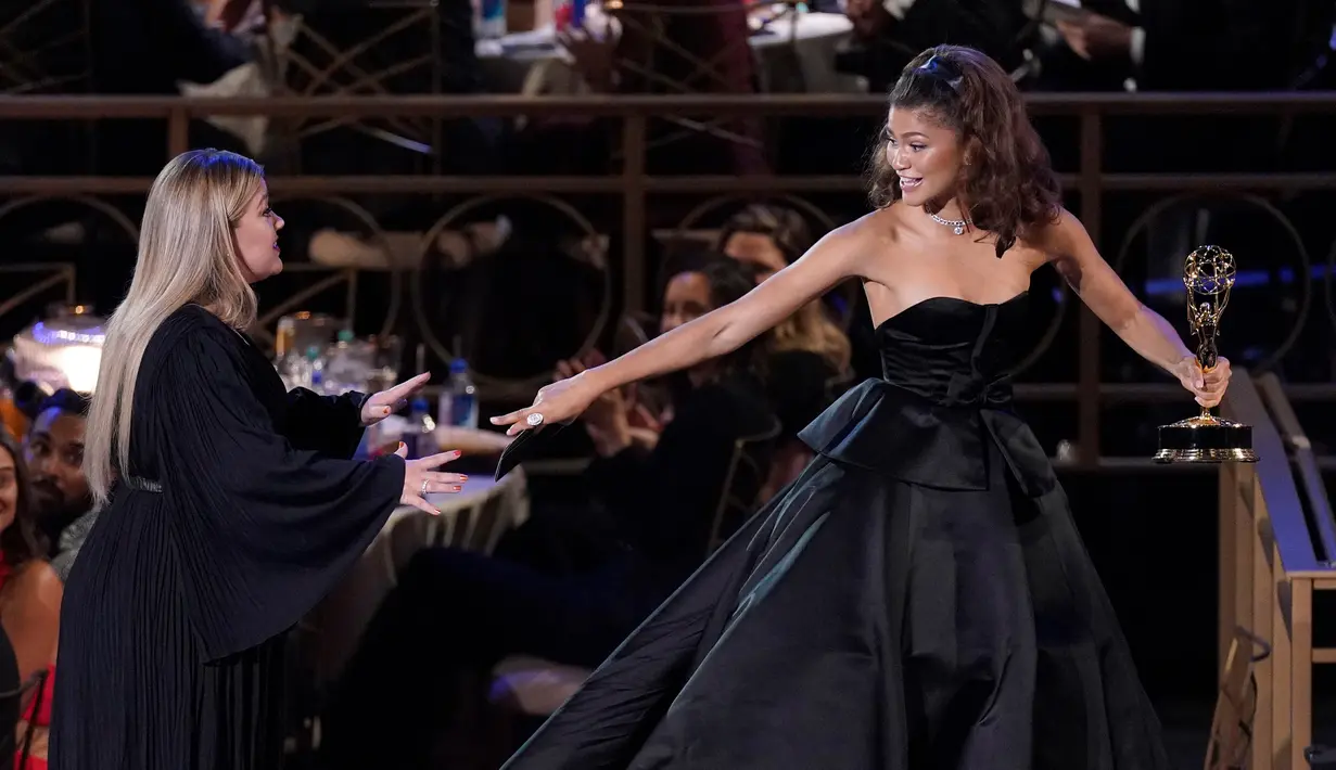Kelly Clarkson (kiri) memberi selamat kepada Zendaya atas penghargaan aktris utama terbaik dalam serial drama 'Euphoria' pada ajang Emmy Awards 2022 di Microsoft Theater, Los Angeles, Amerika Serikat, 12 September 2022. Bintang berusia 26 tahun itu memenangkan kategori tersebut lewat perannya sebagai Rue dalam serial 'Euphoria'. (AP Photo/Mark Terrill)