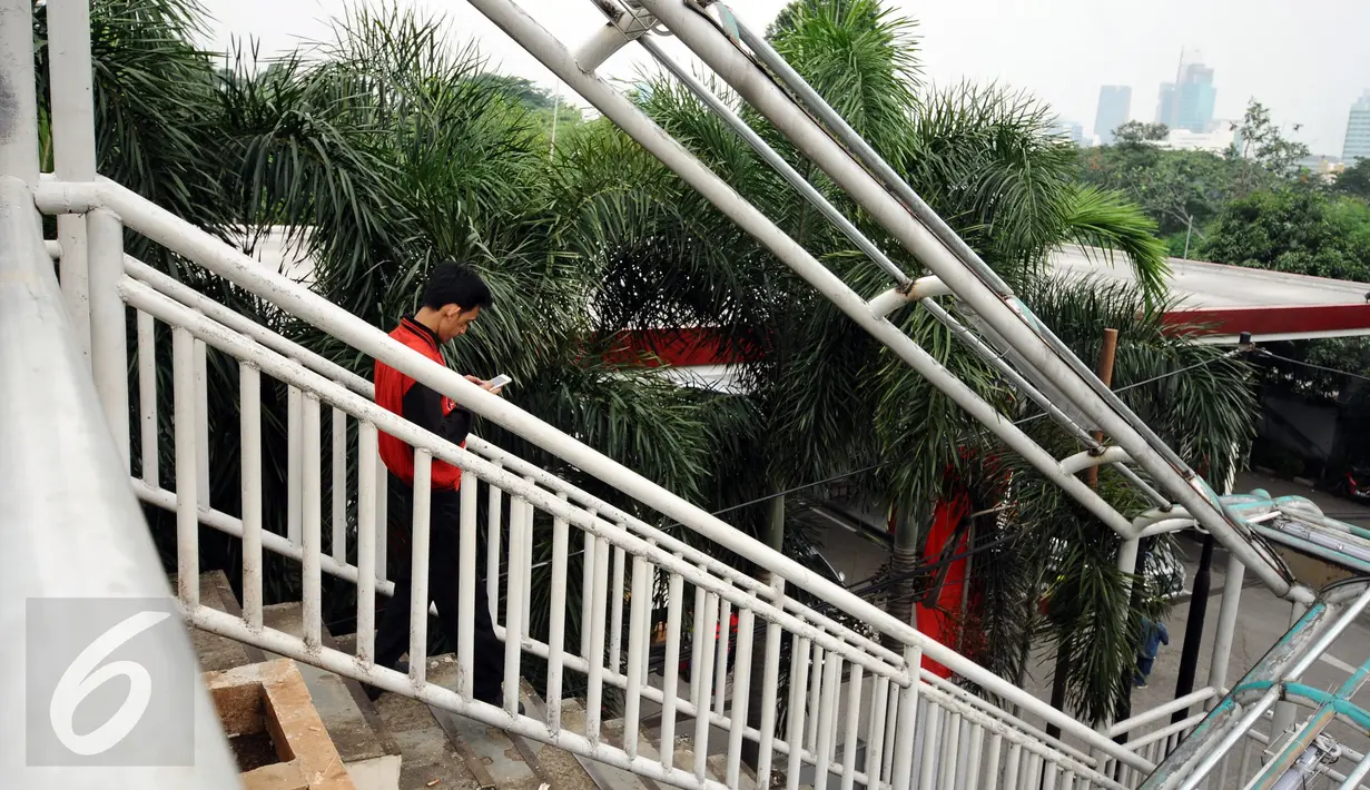 Warga melintasi Jembatan Penyebrangan Orang (JPO) di Jalan Kasblanca, Jakarta, Selasa (22/11). Pemerintah Provinsi DKI Jakarta menargetkan perbaikan JPO tak layak segera rampung. (Liputan6.com/Helmi Fithriansyah)
