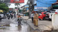 Jalan rusak yang terus tergenang air di Bintara Raya, Bekasi. (Liputan6.com/Bam Sinulingga)