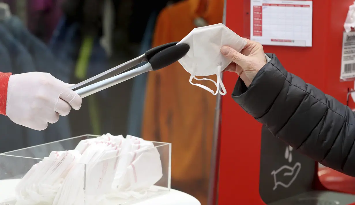 Seseorang mengambil masker FFP2 jenis respirator saat berbelanja di supermarket di Wina, Austria, Senin (25/1/2021). Mulai 25 Januari 2021, warga Austria diwajibkan mengenakan masker FFP2 di supermarket, apotek, pompa bensin, dan di transportasi umum. (AP Photo/Ronald Zak)