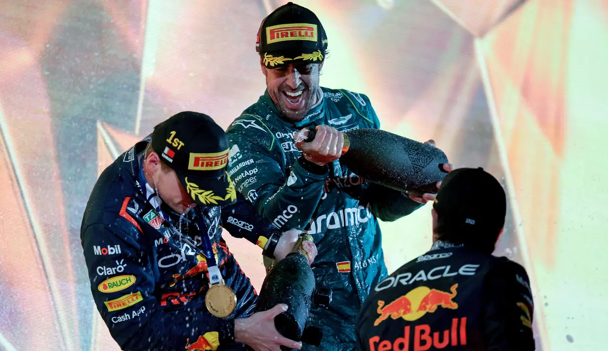 Pebalap Aston Martin, Fernando Alonso (tengah) merayakan kemenangan bersama dua pebalap Red Bull, Max Verstappen dan Sergio Perez saat Formula 1 GP Bahrain 2023 yang berlangsung di Sirkuit Internasional Bahrin, Sakhir, Minggu (05/03/2023) WIB. (AFP/Giuseppe Cacace)