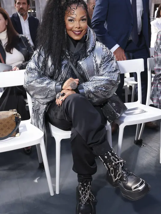 Janet Jackson duduk sambil tersenyum saat menghadiri koleksi busana Louis Vuitton Spring/Summer 2023 yang dipresentasikan selama Paris Fashion Week di Paris pada Selasa, 4 Oktober 2022.  Jackson membiarkan mantel mencolok terbuka untuk memamerkan jaket kulit empuk dan atasan hitam yang dia kenakan di bawahnya. Dia memadukan potongan-potongan berlapis dengan jogging baggy dan mengikatkan tas tangan Louis Vuitton di tubuhnya. (Photo by Vianney Le Caer/Invision/AP)