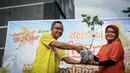 Perwakilan Coolant, Dwianto Arif (kiri) memberikan bibit blimbing kepada Erni Fitratunissa selaku Kepala Bidang Pelestarian & Tata Lingkungan BPLHD kegiatan Coolant Star Fruit di arena Car Free Day, Jakarta, Minggu (25/9). (Liputan6.com/Faizal Fanani)