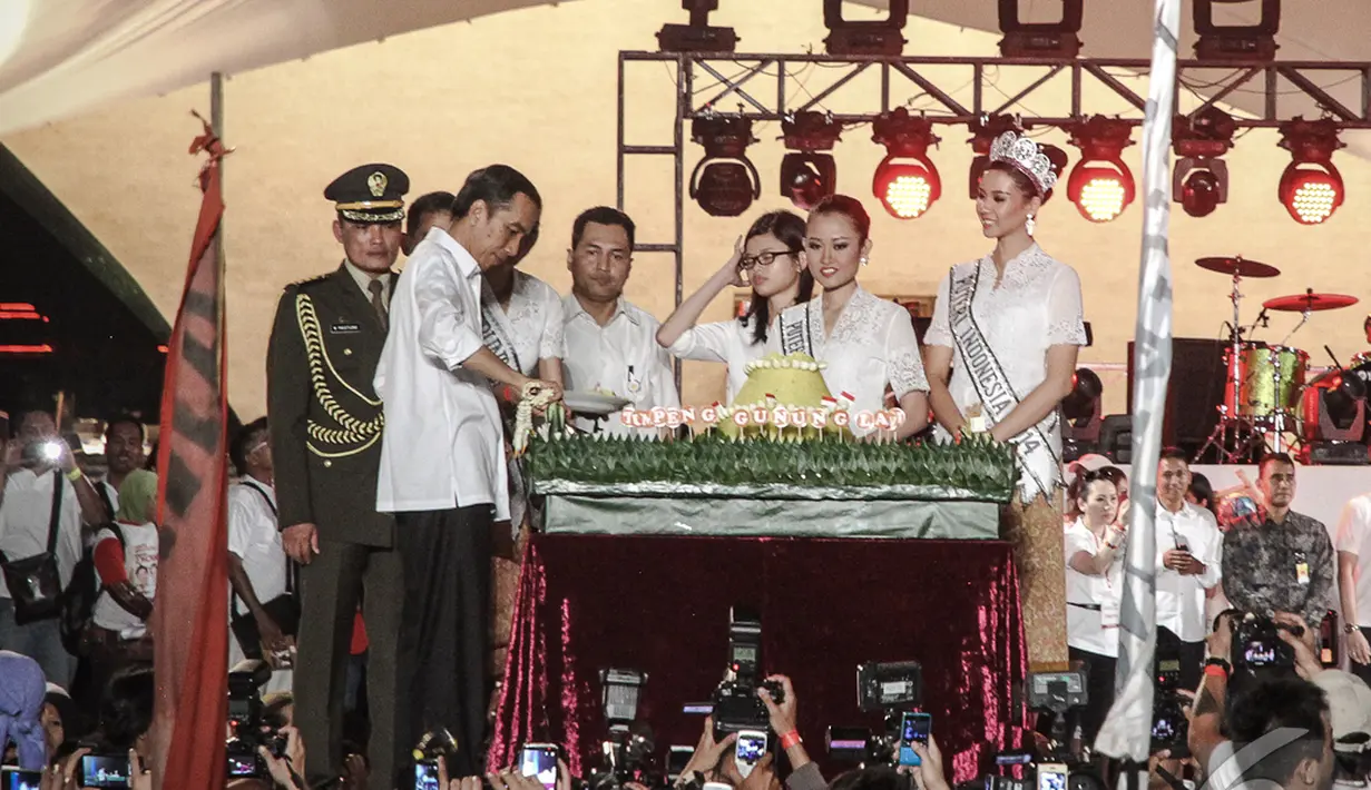 Presiden Jokowi menghadiri Syukuran Rakyat di Monas. Ia tampak memotong Nasi tumpeng yang telah disiapkan, Jakarta Pusat, Senin (20/10/2014) (Liputan6.com/Faizal Fanani)