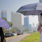 Seorang wanita menggunakan payung selama gelombang panas di Jakarta, Selasa (22/10/2019).  BMKG memprediksi wilayah Indonesia akan mengalami panas selama kurang lebih satu minggu ini. Hal ini dikarenakan matahari yang berada dekat dengan jalur khatulistiwa. (Liputan6.com/Faizal Fanani)