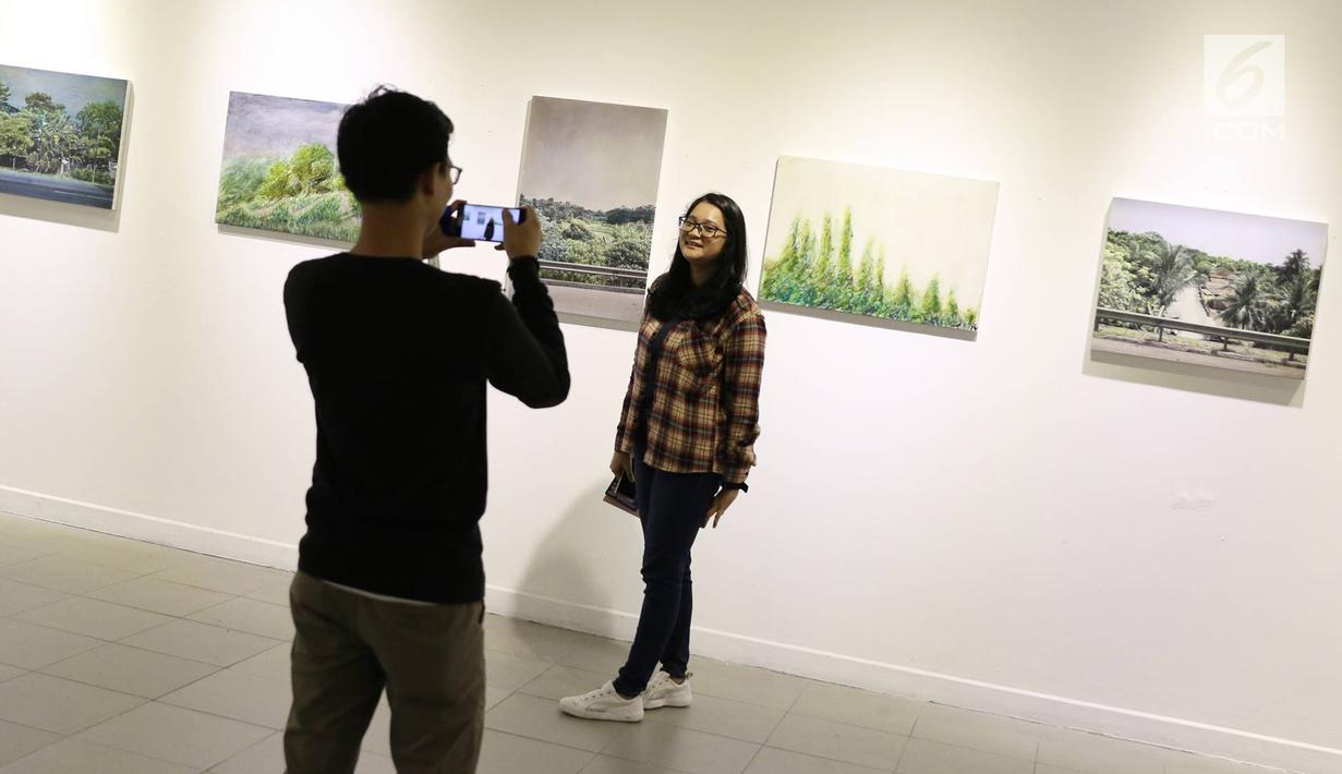 Pengunjung berfoto di depan karya yang dipajang dalam pameran bersama bertajuk 'Mutual Unknown' di Galeri Nasional, Jakarta, Sabtu (3/6). (Liputan6.com/Immanuel Antonius)