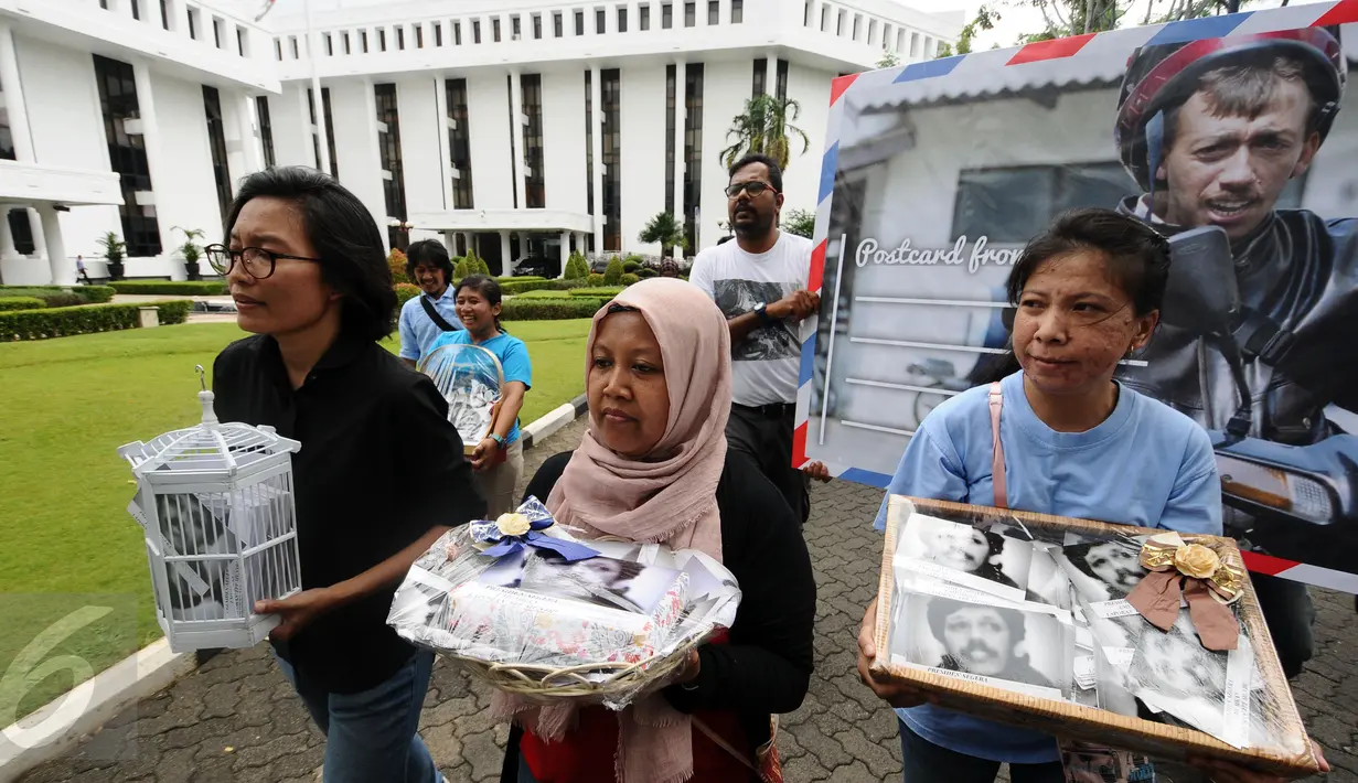 Aktivis KontraS berjalan di halaman Sekretariat Negara untuk menyampaikan Kartu Pos Desak Presiden Selesaikan Kasus Munir, Jakarta, Selasa (17/1). Kartu dikumpulkan dari masyarakat di 20 kota di Indonesia. (Liputan6.com/Helmi Fithriansyah)