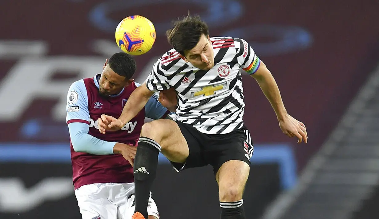 Bek Manchester United, Harry Maguire, duel udara dengan pemain West Ham United, Sebastien Haller, pada laga Liga Inggris di Stadion London, Minggu (6/12/2020). Setan Merah menang dengan skor 1-3. (Justin Setterfield/Pool Via AP)