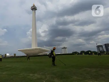 Petugas membersihkan rumput di kawasan Monumen Nasional (Monas) yang akan dijadikan arena lintasan balapan Formula E 2020, Jakarta, Selasa (11/2/2020). Formula E 2020 seri Jakarta akan memakai lintasan Monas untuk balapan mobil listrik Formula E pada 6 Juni 2020. (merdeka.com/Imam Buhori)
