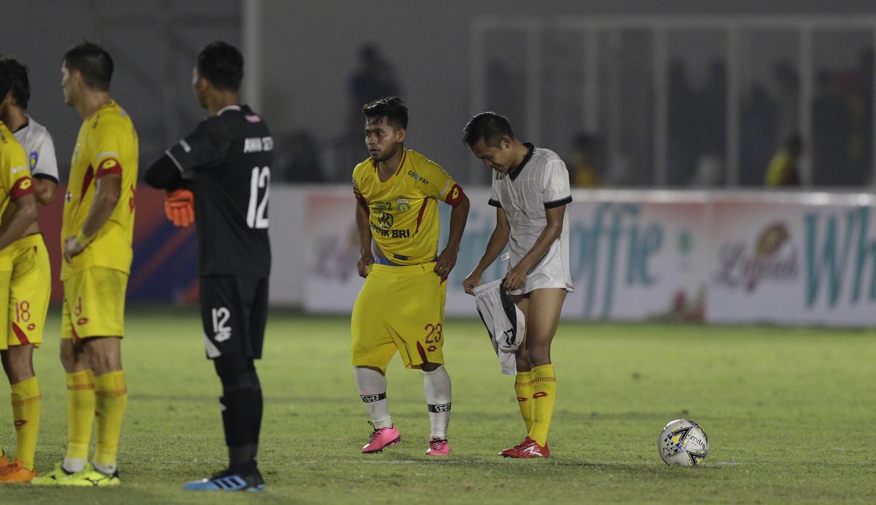 Gelandang Madura United, Andik Vermansah, bertukar jersey dan celana dengan gelandang Bhayangkara FC, Wahyu Suboseto, pada laga Liga 1 2019 di Stadion Madya, Jakarta, Senin (5/8). Kedua tim bermain imbang 1-1. (Bola.com/M iqbal Ichsan)