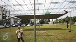 Para santri memasang tenda untuk pemakaman tokoh PBNU KH Hasyim Muzadi di Kompleks Ponpes Al Hikam, Depok, Kamis (16/3). Jenazah Hasyim Muzadi akan diberangkatkan dari Malang menuju ponpes Al Hikam usai salat zuhur. (Liputan6.com/Immanuel Antonius)