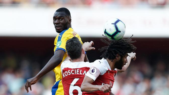 Duel udara terjadi antara Christian Benteke dan Koscielny pada laga lanjutan Premier League yang berlangsung di Stadion Emirates, Minggu (21/4). Arsenal kalah 2-3 kontra Crystal Palace. (AFP/Adrian Dennis)