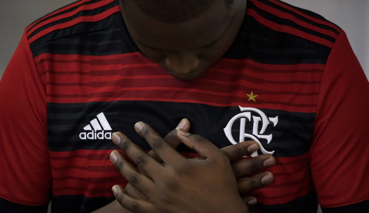 Seorang pria mengenakan jersey Flamengo berdoa saat Misa peringatan untuk para korban kebakaran di akademi sepakbola Brasil, di Rio de Janeiro, Brasil (8/2). Kebakaran tersebut menewaskan 10 pemain muda dan tiga luka-luka. (AP Photo/Leo Correa)
