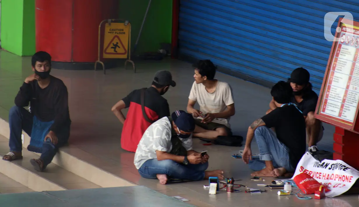 Aktivitas penjual jasa perbaikan telepon genggam di sekitar Mall Pusat Grosir Cililitan, Jakarta, Kamis (14/5/2020). Menurut salah satu penjual jasa, aktivitas mereka disebabkan penutupan Mall Pusat Grosir Cililitan sebagai imbas pemberlakuan PSBB.  (Liputan6.com/Helmi Fithriansyah)