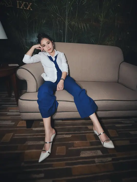 Ia padukan setelan jasnya dengan dasi yang senada dan mules heels berwarna putih [@prillylatuconsina96]