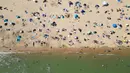 Foto udara menunjukkan orang-orang bermain dan bersantai di bawah sinar matahari di Pantai Bournemouth, Selatan Inggris pada Selasa 26 Mei 2026, saat kondisi gelombang panas menyebar ke sebagian wilayah tenggara Inggris dan London. (JUSTIN TALLIS/AFP)