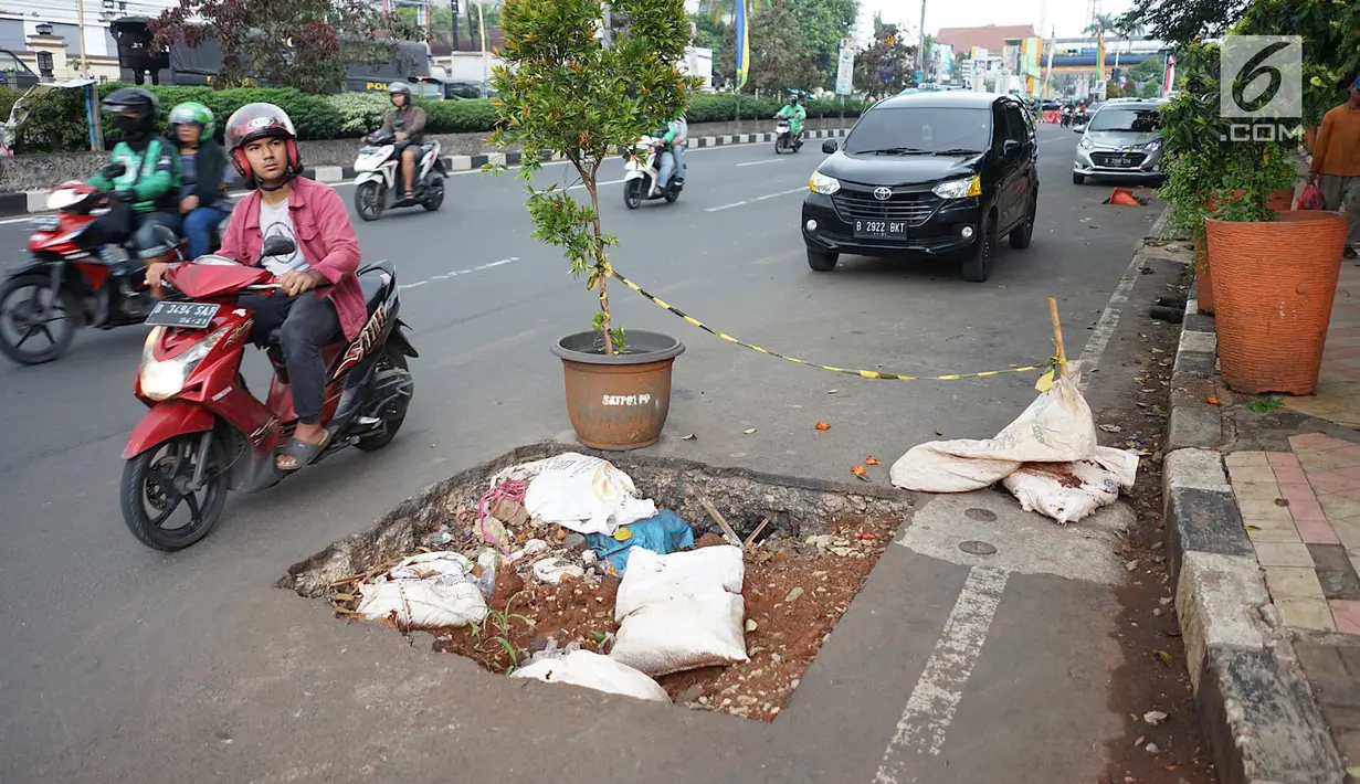 Kendaraan melintas di samping bekas galian proyek yang tidak tuntas pengerjaannya di Jalan Margonda Raya, Depok, Jawa Barat, Kamis (9/5/2019). Kondisi jalan yang diabaikan selama beberapa bulan terakhir tersebut memersempit dan mengganggu aktivitas warga. (Liputan6.com/Immanuel Antonius)