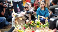 Nikita Mirzani saat menyiram air mawar di pusara Olga Syahputra di TPU Malaka seusai bebas dari Rutan  Bambu pagi tadi, Jakarta, Senin (30/3/2015). (Liputan6.com/Panji Diksana)