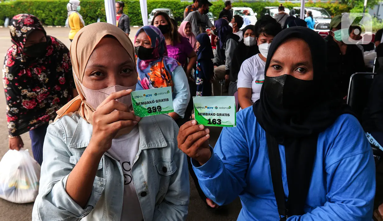 Warga memperlihatkan kupon saat akan mengambil paket sembako di di Studio 5 Indosiar, Jakarta Barat, Rabu (19/10/20). Dalam rangka HUT ke-30, PT Adaro bekerja sama dengan Yayasan Pundi Amal Peduli Kasih (YPP), Indosiar dan SCTV memberikan 30.000 paket sembako kepada masyarakat seluruh Indonesia. (Liputan6.com/Angga Yuniar)