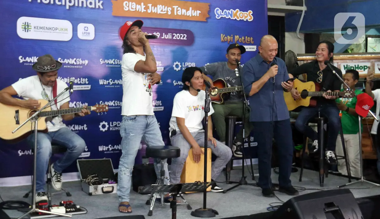 Grup band Slank bernyanyi bersama Menteri Koperasi dan UKM Teten Masduki (kanan depan) usai peluncuran Slankops di Basecamp Slank, Jakarta, Selasa (19/7/2022). Slank bersama Menteri Koperasi dan UKM Teten Masduki dan Menteri BUMN Erick Thohir bernyanyi bersama membawakan lagu 'Ku Tak Bisa' dan 'Balikin'. (Liputan6.com/Herman Zakharia)