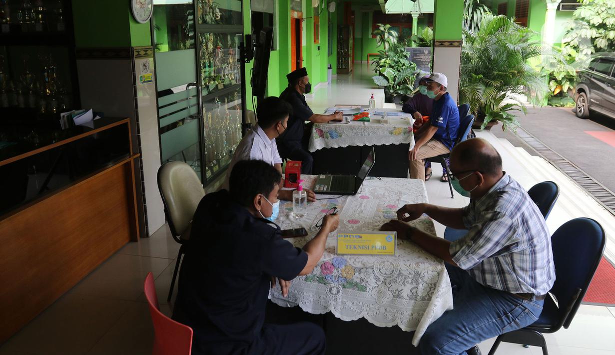 Orang tua murid mencari informasi pengajuan akun untuk mengikuti proses Penerimaan Peserta Didik Baru (PPDB) Tahun Pelajaran 2021/2022 di SMA Negeri 87 Jakarta, Senin (7/6/2021).  Proses PPDB DKI Jakarta yang mulai dibuka sejak hari ini, Senin (7/6). (Liputan6.com/Herman Zakharia)