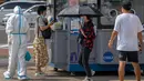 Seorang pekerja yang mengenakan pakaian pelindung menyemprotkan disinfektan ketika seorang wanita menunggu tenggorokannya diusap untuk tes COVID-19 di fasilitas pengujian virus corona di Beijing, China, Jumat (12/8/2022). REPUBLIKA.CO.ID, BEIJING -- Beberapa kota di China yang sedang dilanda wabah Covid-19 menerapkan peraturan pembatasan sosial baru. (AP Photo/Mark Schiefelbein)