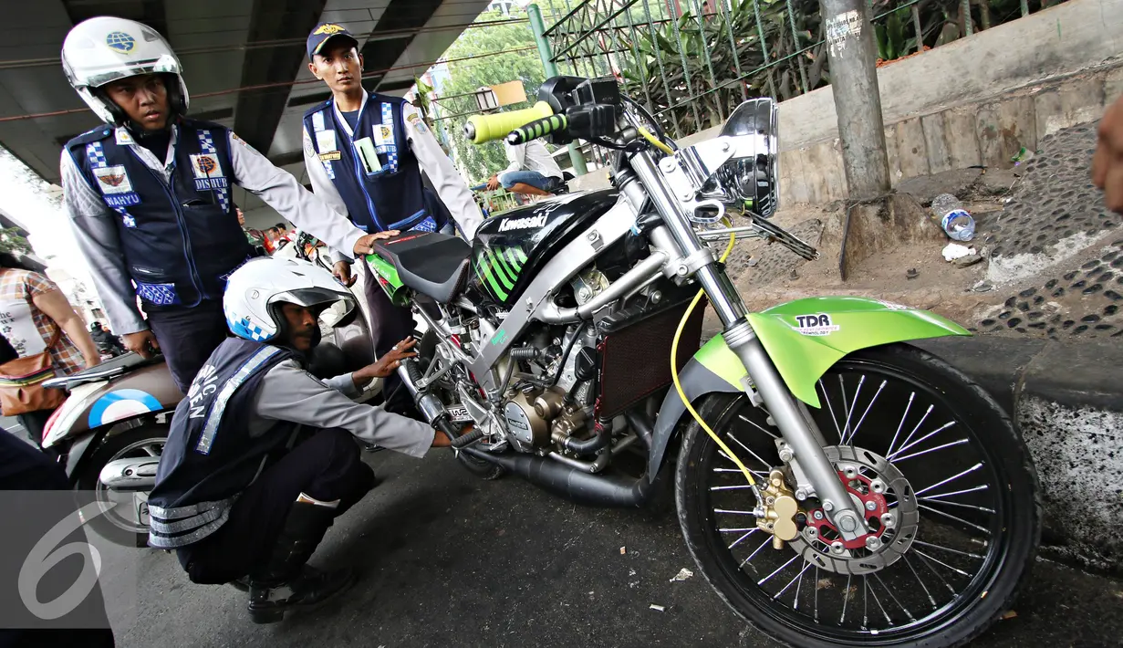 Petugas Dishub mencabut pentil kendaraan roda dua dalam operasi penertiban parkir liar di Pusat, Jumat (23/10/2015). Meskipun informasi penertiban diduga telah bocor, ratusan kendaraan yang parkir liar tetap ditertibkan. (Liputan6.com/Immanuel Antonius)