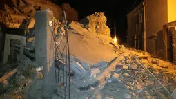 Sejumlah orang berdiri di dekat bangunan yang rusak akibat gempa di Pulau Ischia, Italia (21/8). Akibat gempa tersebut satu orang tewas dan tujuh lainnya hilang. (@ Percy80 via AP)