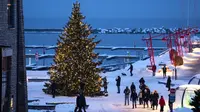 Orang-orang berjalan mengelilingi pohon cemara yang dihias untuk perayaan Natal dan Tahun Baru di Pelabuhan Noblessner, Teluk Tallinn, Estonia, 16 Desember 2023. (AP Photo/Pavel Golovkin)
