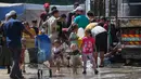 Di kamp Nuseirat, Jalur Gaza Tengah,para pengungsi langsung mengisi wadah mereka ketika bantuan air bersih yang dibawa salah satu truk bantuan tiba. (Eyad BABA/AFP)