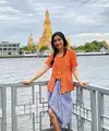Berlibur ke Bangkok, Febby tampil mengenakan kebaya kutu baru warna orange dipadukan kain batik biru yang dijadikan skirt. [Instagram/@febbyrastanty]