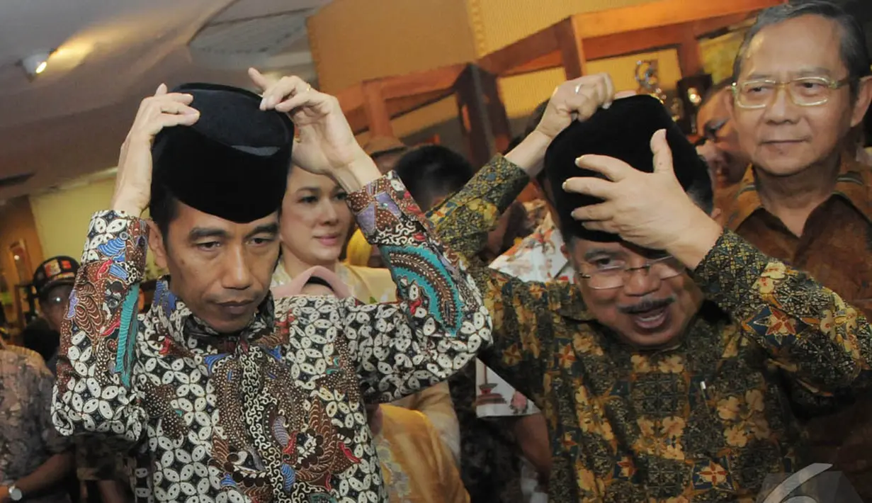Jokowi dan JK mencoba kopiah secara bersamaan, Pasaraya Blok M, Jakarta, Kamis (2/10/2014) (Liputan6.com/Herman Zakharia)