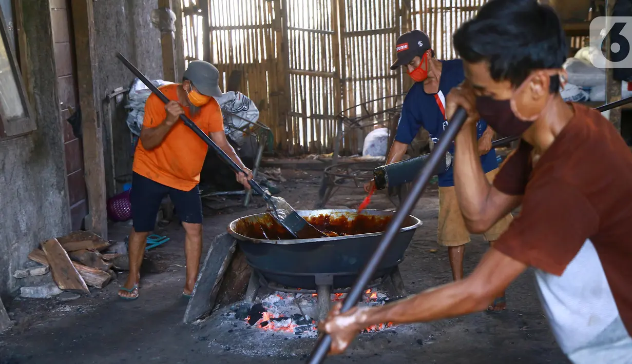 Pekerja mengaduk adonan dodol di pabrik dodol Betawi Mugi Jaya, Cilenggang, Tangerang Selatan, Rabu (13/5/2020). Produksi dodol selama pandemi Covid-19 menggunakan dua tungku. (Liputan6.com/Fery Pradolo)