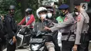 Petugas dari Korps Brimob memeriksa surat keterangan warga saat penyekatan di Jalan Lenteng Agung Raya, Jakarta, Selasa (6/7/2021). Petugas hanya mengizinkan warga yang memiliki kepentingan esensial atau mendesak bisa melintas jalan Lenteng Agung Raya. (Liputan6.com/Helmi Fithriansyah)