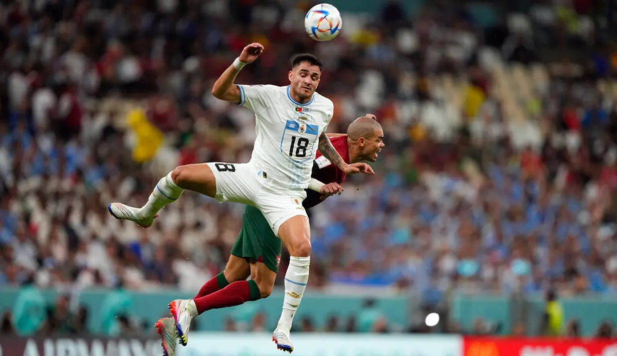 Pemain Uruguay Maxi Gomez (kiri) berebut bola dengan pemain Portugal Pepe pada pertandingan sepak bola Grup H Piala Dunia 2022 di Stadion Lusail, Lusail, Qatar, 28 November 2022. Portugal mengalahkan Uruguay dengan skor 2-0. (AP Photo/Martin Meissner)