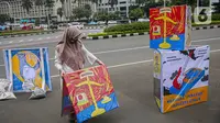 Seorang yang tergabung dalam Koalisi Masyarakat Peduli Kesehatan (KOMPAK) menunjukkan poster saat menggelar aksi #ParadeMural di kawasan Patung Arjuna Wijaya, Jakarta, Rabu (17/11/2021). Aksi juga dilakukan untuk menyambut Hari Kesehatan Nasional 2021. (Liputan6.com/Faizal Fanani)