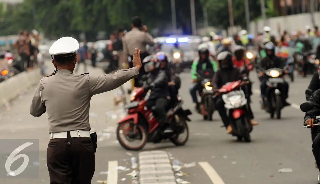Polisi mengatur lalu lintas di Jalan Medan Merdeka Timur usai ribuan massa ormas melakukan unjuk rasa di Bareskrim Polri, Gedung KKP Jakarta, Jumat (14/10). Dalam aksinya, massa meminta Basuki Tjahaja Purnama ditahan. (Liputan6.com/Helmi Fithriansyah)