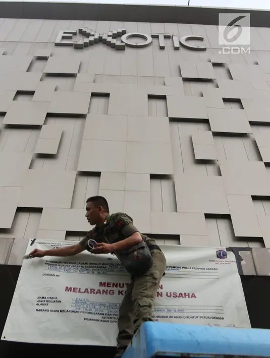 Petugas Satpol PP memasang banner penutup  saat menyegel Diskotek Exotic di Mangga Besar, Jakarta, Kamis (19/4). Petugas tidak memberi keterangan perihal penutupan diskotek yang sudah tidak aktif sejak 15 April 2018 lalu (Liputan6.com/Arya Manggala)