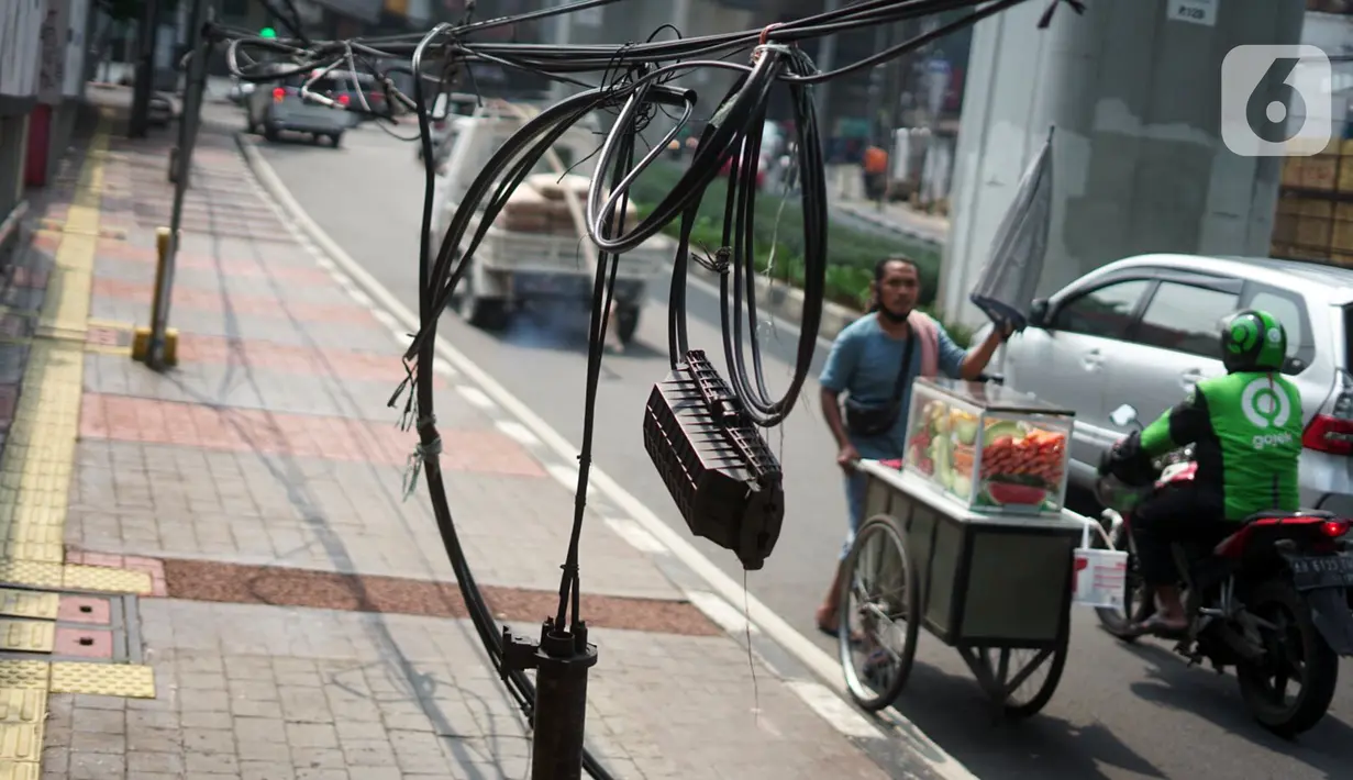 Instalasi kabel yang semrawut terlihat di Jalan Kyai Maja, Kebayoran Baru, Jakarta Selatan, Rabu (11/11/2020). Kurangnya penataan menjadi penyebab instalasi kabel di Ibu Kota kian semrawut sehingga mengganggu kenyamanan serta keselamatan warga. (Liputan6.com/Immanuel Antonius)