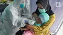Paramedis melakukan swab test PCR kepada seorang anak di Puskesmas Kramat Jati, Jakarta Timur, Rabu (13/1/2020). Setiap harinya, Puskesmas Kramat Jati menyediakan kuota 300 swab test PCR  secara gratis untuk memutus mata rantai penyebaran COVID-19. (merdeka.com/Arie Basuki)