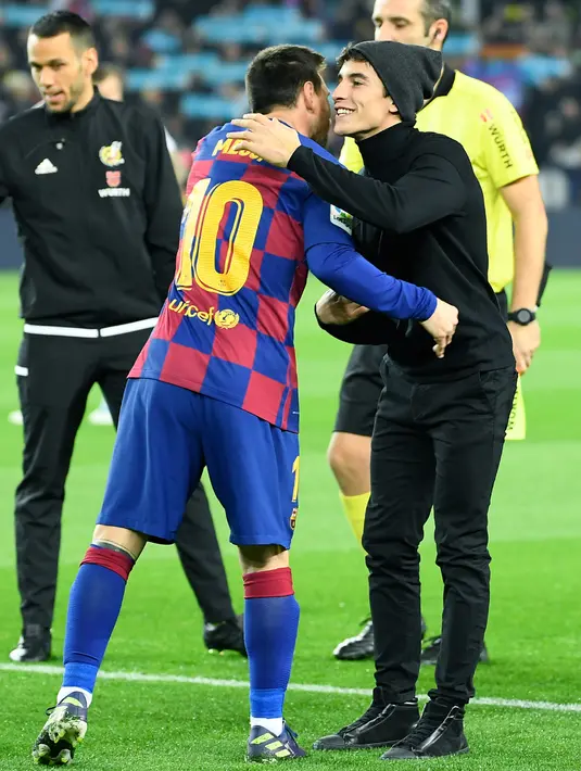 Pembalap Repsol Honda, Marc Marquez (kanan) memeluk penyerang Barcelona, Lionel Messi sebelum pertandingan Liga Spanyol "El Clasico" antara Barcelona melawan Real Madrid di Camp Nou Stadium (18/12/2019). Dalam laga ini, Barcelona dan Real Madrid bermain imbang 0-0. (AFP/Lluis Gene)