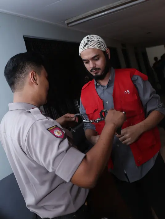 Petugas melepas borgol di pergelangan tangan Rio Reifan sebelum sidang digelar. (Galih W. Satria/Bintang.com)