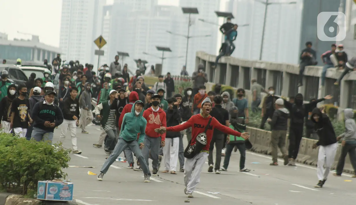 Sejumlah anak muda terlibat bentrok saat massa aksi demo mahasiswa di depan Gedung DPR, Jakarta, Senin (11/4/2022). Mahasiswa yang tergabung dalam aliansi BEM SI menggelar unjuk rasa besar-besaran di depan Gedung DPR/MPR RI, Senin ini. (Liputan6.com/Angga Yuniar)