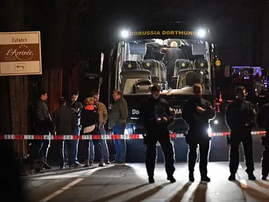 Polisi berjaga di depan bus tim Borussia Dortmund yang rusak terkena ledakan bom di Dortmund, Jerman Barat, Selasa (11/4). Bus membawa pemain Borussia Dortmund untuk pertandingan perempat final Liga Champions melawan Monaco. (AP Photo/Martin Meissner)