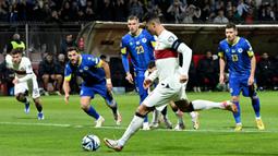 Striker Timnas Portugal, Cristiano Ronaldo mencetak gol pertama ke gawang Bosnia Herzegovina lewat eksekusi penalti pada laga lanjutan Grup J Kualifikasi Euro 2024 di Stadion Bellino Polje, Selasa (17/10/2023) dini hari WIB. (AFP/Elvis Barukcic)