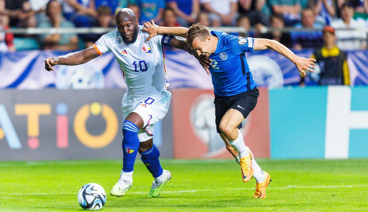 Pemain Belgia, Romelu Lukaku (kiri) berebut bola dengan pemain Estonia, Marten Kuusk pada laga Grup F Kualifikasi Euro 2024 yang berlangsung di A. Le Coq Arena, Tallinn, Estonia, Rabu (21/06/2023) dini hari WIB. Lukaku sukses mencetak dua gol untuk kemenangan 3-0 Belgia. (AP Photo/Pavel Golovkin)